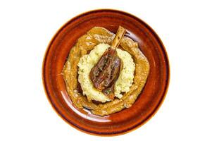 Stew goat Shanks with mash potato on a plate. Isolated on white background. photo