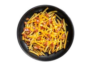 French fries baked with cheddar cheese and bacon in a pan. Isolated on white background. photo
