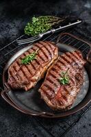 Grilled Top Blade or flat iron beef meat steaks. Black background. Top View photo