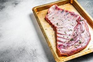 Marinated lamb mutton ribs with herbs and thyme in baking dish. White background. Top view. Copy space photo