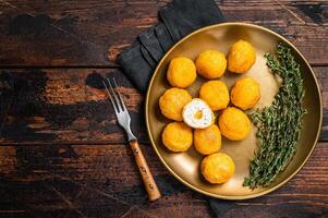 Fried crispy round chicken nuggets with Cheese. Wooden background. Top view. Copy space photo