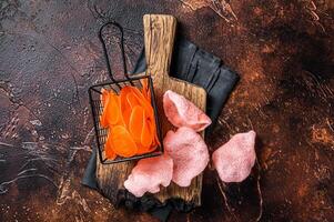 Cooking raw kerupuk or prawn shrimp crackers, chips. Asian fastfood. Dark background. Top view photo