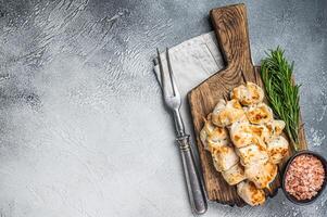 Chicken kebab skewers with onion and spices on wooden board. White background. Top view. Copy space photo