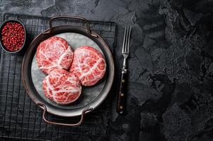 Raw pork cutlet, Crepinette with spices and herbs. Black background. Top view. Copy space photo