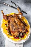 Christmas roast duck with apples and oranges, festive christmas recipe. Gray background. Top view photo