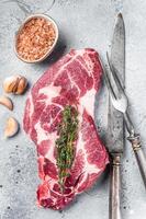 Raw Pork steaks, fresh meat on butcher table. Gray background. Top view photo
