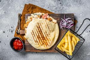Doner kebab, Shawarma in grilled pita bread with vegetables and meat. Gray background. Top view photo
