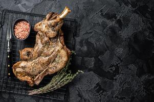 Barbecue Roasted lamb mutton shoulder meat with herbs and spices. Black background. Top view. Copy space photo