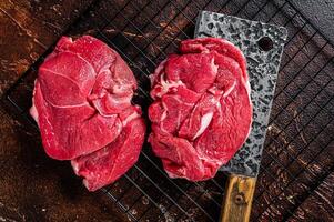 Raw Lamb fillet steaks with herbs and spices, uncooked mutton meat. Dark background. Top view photo