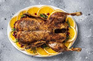 Christmas roast duck with apples and oranges, festive christmas recipe. Gray background. Top view photo