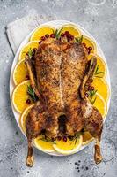 Christmas roast duck with apples and oranges, festive christmas recipe. Gray background. Top view photo