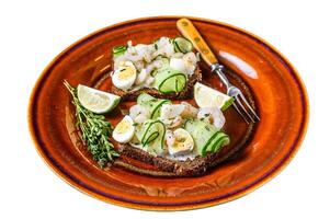 Scandinavian Sandwiches with shrimp, prawns, quail eggs and cucumber on rye bread. Isolated on white background. photo