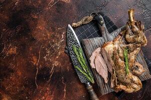 Slow Cooked grilled lamb mutton shoulder meat with herbs and spices on wooden board. Dark background. Top view. Copy space photo