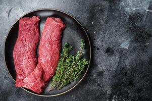 Halal fresh lamb tenderloin meat, Mutton sirloin fillet with thyme. Black background. Top view. Copy space photo