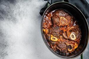 Osso buco cross cut veal shank braised with tomatoes and spices, beef meat Ossobuco. White background. Top view. Copy space photo