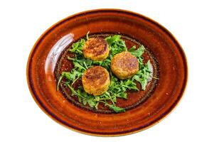 Roasted chickpeas falafel patties with arugula on a plate. Isolated on white background. photo