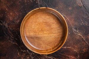 Table setting with vintage empty wooden plate on rustic wood. Dark background. Top view. Copy space photo