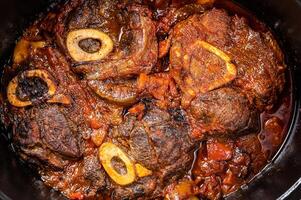 Osso buco cross cut veal shank braised with tomatoes and spices, beef meat Ossobuco. White background. Top view photo