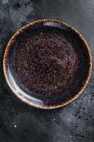 Empty black craft plate on table. Table setting. Black background. Top view. Copy space photo