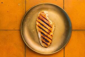 Grilled Chicken breast steak on a plate, fried poultry meat, top view. photo