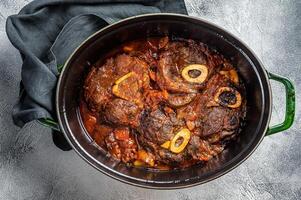 Osso buco cross cut veal shank braised with tomatoes and spices, beef meat Ossobuco. White background. Top view photo
