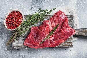Skirt or Machete beef steak, raw meat with herbs and spices. Gray background. Top view photo