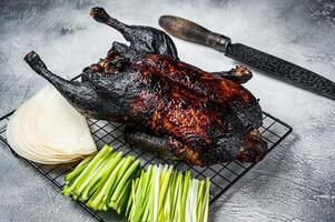 Whole roast Peking duck with herbs, sauce, rice Pancake, Cucumber and onion. White background. Top view photo