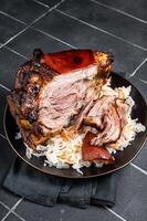Roast Pork Ham Hock, knuckle with Sauerkraut on a plate. Black background. Top view photo