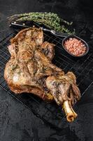 Barbecue Roasted lamb mutton shoulder meat with herbs and spices. Black background. Top view photo