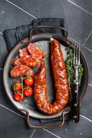 Sliced Chorizo sausage, slices of dry cured pork with herbs and spices. Black background. Top view photo