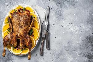 Christmas roast duck with apples and oranges, festive christmas recipe. Gray background. Top view. Copy space photo