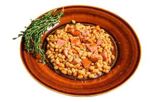 Kidney beans with smoked sausage and tomato sauce in a plate. Isolated on white background. photo