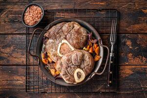 Veal shank stew Osso Buco, italian ossobuco meat steak. Wooden background. Top view photo
