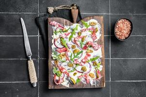 Butterboard, Butter Board with olives, onion, arugula, capers and tomato. Black background. Top view photo