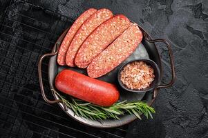 Turkish Sliced Sucuk beef meat sausage ready for cooking. Black background. Top view photo