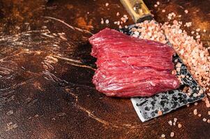 Butcher board with Raw Venison dear meat steak. Dark background. Top view. Copy space photo