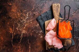 Cooking raw kerupuk or prawn shrimp crackers, chips. Asian fastfood. Dark background. Top view. Copy space photo