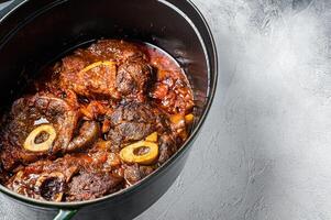 Osso buco cross cut veal shank braised with tomatoes and spices, beef meat Ossobuco. White background. Top view. Copy space photo