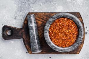 Cooking of Red Chili pepper and paprika flakes. grey background. top view photo