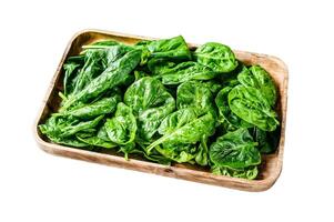 Young spinach leaves in a wooden bowl with goat cheese. Isolated on white background. Top view. photo