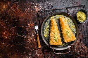 Turkish Havuc Dilim Baklava with pistachio. Dark background. Top view. Copy space photo