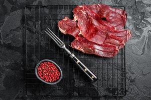 Dried sliced basturma, cured beef meat ready for eat. Black background. Top view photo