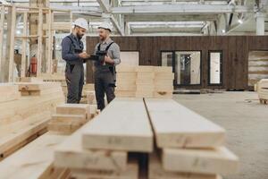 Construction workers discussing plans in modular building factory photo
