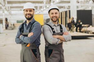 Engineers smiling with arms crossed in modular building factory photo