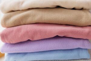 Stack of colorful fleece jackets creating cozy winter mockup photo