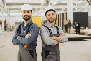 Construction workers smiling with arms crossed in modular building factory photo