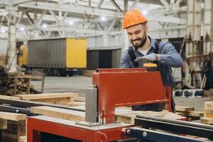 Carpenter operating woodworking machine in timber factory for modular building photo