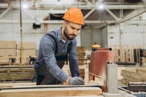 Carpenter marking wooden plank in workshop for modular building production photo
