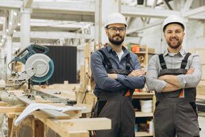 Construction workers smiling with arms crossed in modular building factory photo
