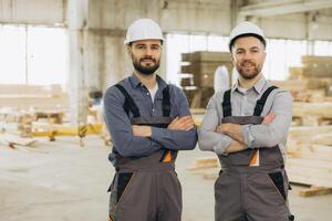 Construction workers smiling with folded arms in modular building industry factory photo